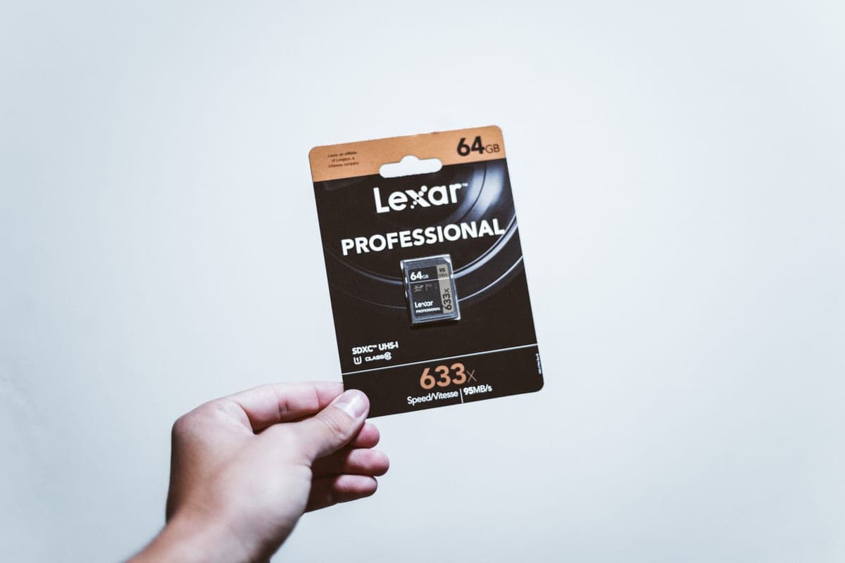 A hand holding a packaged SD memory card
